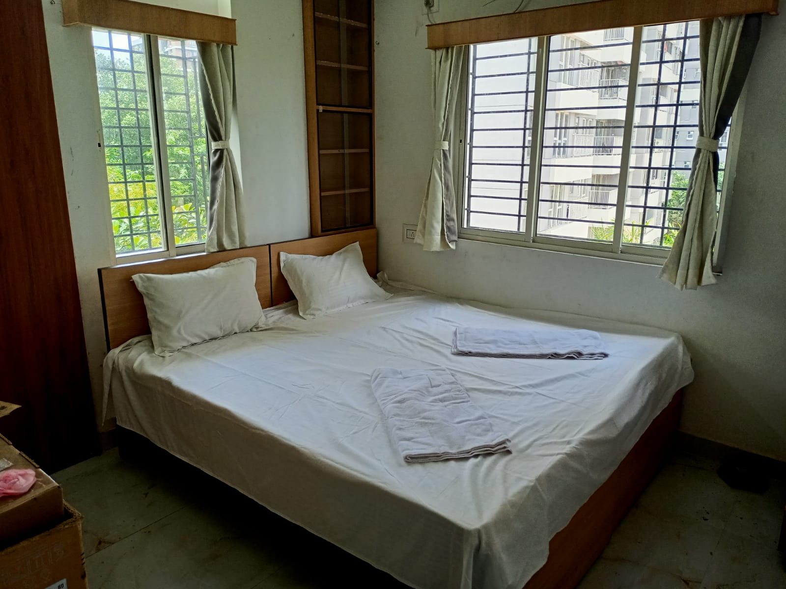 Airy Bedroom with Dual Windows & Greenery View